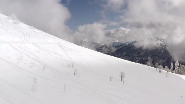 Skier Riding Freeride on Ski From Snowy Slope in Winter Mountain Aerial View