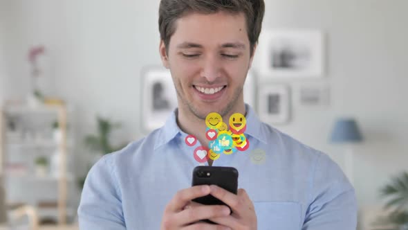 Happy Man Text Messaging on Smartphone Flying Emojis Smileys and Likes