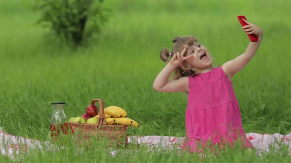 Weekend at Picnic. Girl on Grass Meadow Makes Selfie on Mobile Phone. Video Call, Blog, Play Games