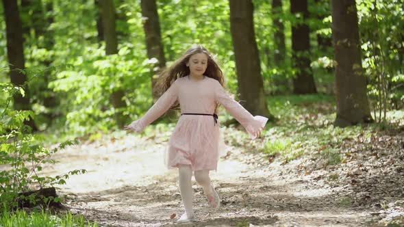 Girl Runs Along a Forest Road
