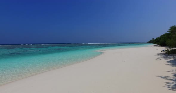 Wide angle fly over travel shot of a summer white paradise sand beach and aqua blue water background