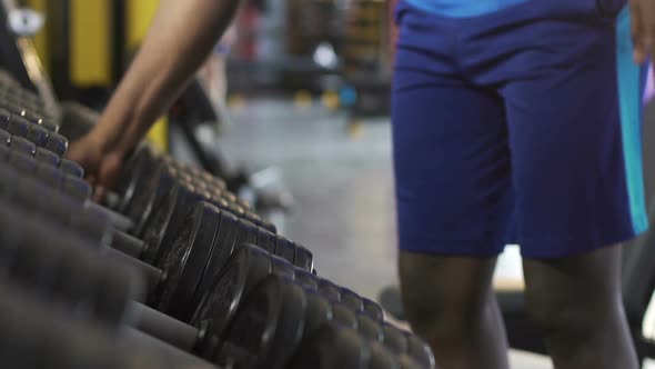 Males Taking Heavy Dumbbells From Stand in Gym, Physical Workout, Weight Lifting