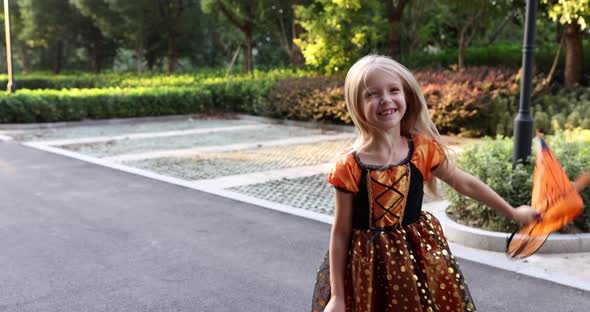 Cute Little Caucasian Girl with Blonde Hair Seven Years Old in Costume of Witch with Hat and Black