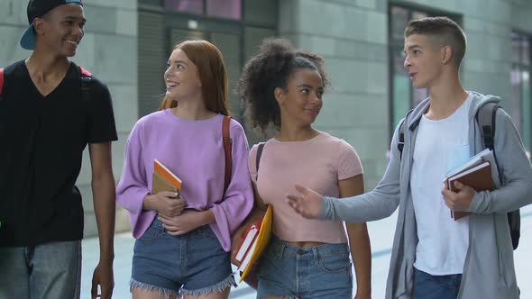 Smiling Multiracial Men and Female Students Discussing Last Lesson and Laughing