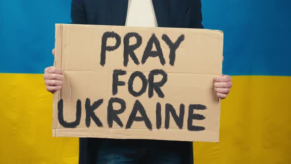 Boy Holds in Hand Cardboard with Inscription Pray for Ukraine