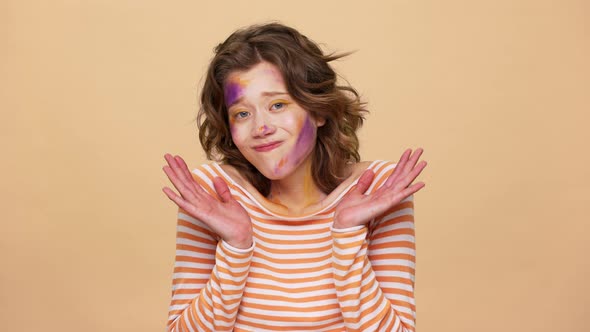Portrait of Brunette Woman Having Multicolored Painted Spots on Face Thrugging and Throwing Up Hands