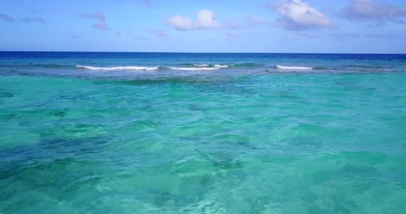 Beautiful drone tourism shot of a sunshine white sandy paradise beach and aqua turquoise water backg