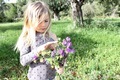 A girl in a green field holding some freshly picked wild flowers in spring  - PhotoDune Item for Sale