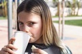 Girl drinking from a disposable cup in the sunshine - PhotoDune Item for Sale