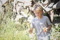 Boy collecting Easter eggs on an egg hunt in the sunshine in nature - PhotoDune Item for Sale
