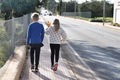 Kids walking on a pavement by an empty road. From behind - PhotoDune Item for Sale