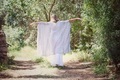 Woman dressed in white walking from behind in a nature forest  - PhotoDune Item for Sale