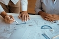 Architects engineer working with blueprints on table and discussing project together at the meeting  - PhotoDune Item for Sale