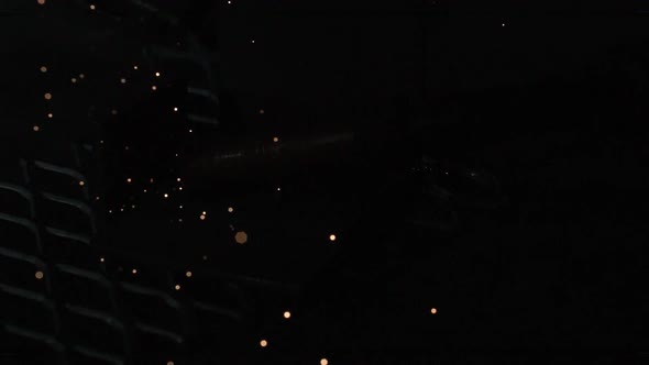 Slow motion of sparks flying while welding from arc welder.