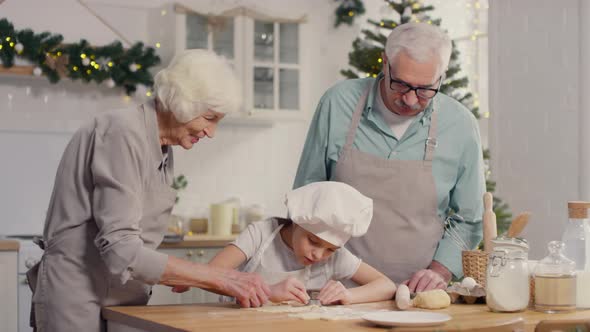 Cute Girl and Grandparents Making Cookies on Christmas