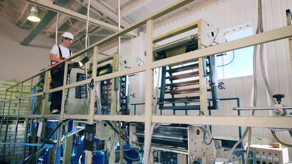 Male Factory Worker Inspecting a Polyethylene Factory with His Laptop