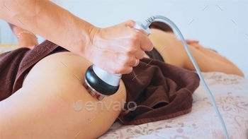 nti-cellulite program for health and slimming. Close-up of the apparatus massages buttocks and hips of young female.