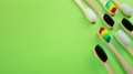Black white and rainbow bamboo toothbrushes on green background - PhotoDune Item for Sale