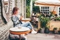 Woman using phone in outdoor cafe. - PhotoDune Item for Sale
