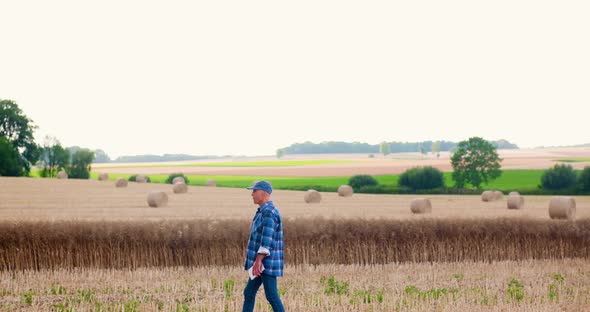 Farmer Using Digital Tablet While Examining Field