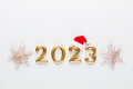 New year 2023 number, golden digits and santa hat over blue background. - PhotoDune Item for Sale