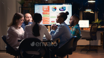 Diverse coworkers brainstorming in business meeting, discussing analytics presentation