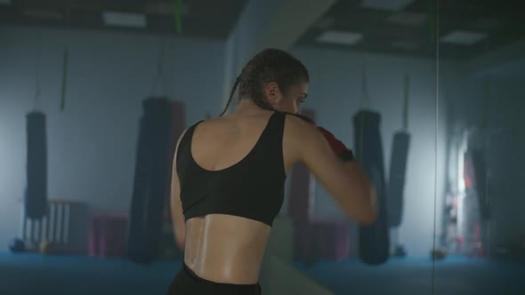 Woman Fighter Trains His Punches and Defense in the Boxing Gym a Boxer Trains in Front of a Mirror