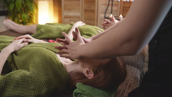 Young Beautiful and Healthy Redhead Woman Getting Spa Treatment Isolated in Candlelight Room