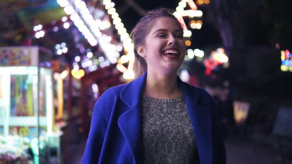 Happy Young Woman Walking in Amusement Park Smiling and Laughing