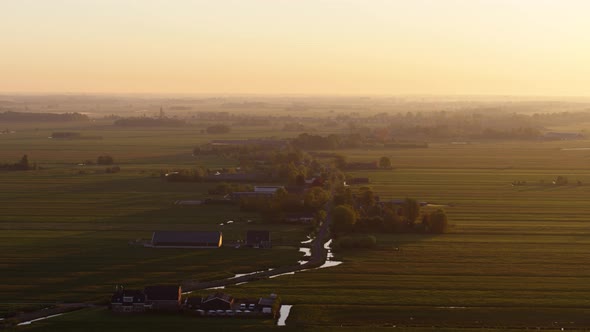 Early misty morning in small rural town, majestic sunrise, aerial drone view