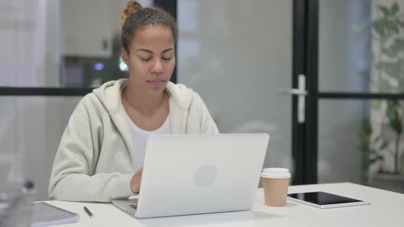 African Woman Having Wrist Pain While Using Laptop in Office