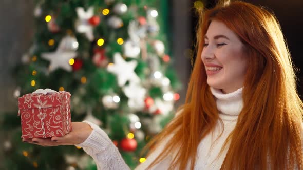 Beautiful Happy Red-haired Woman Sitting Background Christmas Tree and Smiling