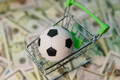 Soccer ball in shopping cart on usa dollar banknotes background. Football cup earnings. - PhotoDune Item for Sale