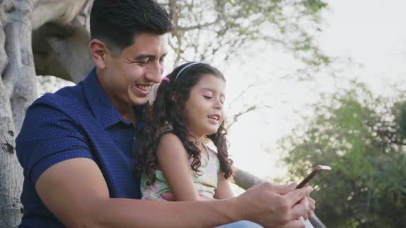 Dad and Daughter Looking at Cell Phone