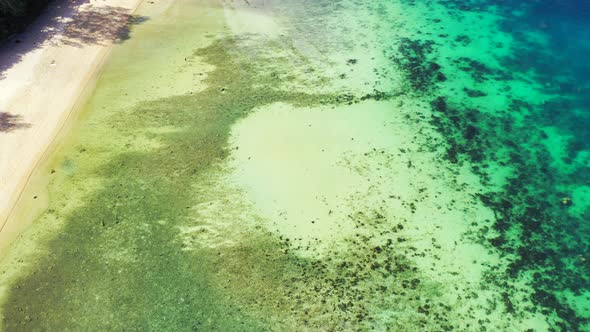 Beautiful fly over abstract shot of a white sandy paradise beach and aqua turquoise water background