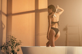 Young asian woman taking care of her body with brush, standing in bathtub in the morning - PhotoDune Item for Sale