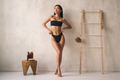 Full length shot of asian woman posing in black bikini near wall in the bathroom - PhotoDune Item for Sale