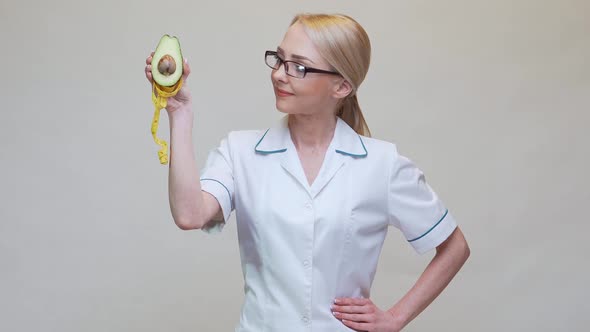 Nutritionist Doctor Healthy Lifestyle Concept - Holding Organic Avocado Fruit and Measuring Tape