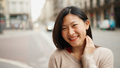 Cheerful Asian woman looking at camera smiling standing on the city street. Happy emotions - PhotoDune Item for Sale