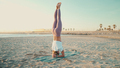Amazing shot of strong yogi girl standing on her head doing yoga poses by the sea - PhotoDune Item for Sale