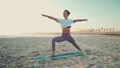 Beautiful yogi girl in sportswear standing in warrior yoga pose on the beach - PhotoDune Item for Sale