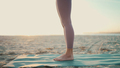 Close up woman wearing leggings standing on yoga mat. Close up female legs on beach - PhotoDune Item for Sale