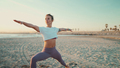 Strong yogi girl in sportswear standing in warrior yoga pose on beach - PhotoDune Item for Sale
