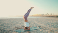 Gorgeous yogi girl doing headstand while practicing yoga poses by the sea - PhotoDune Item for Sale
