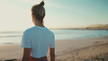 Back view of blond woman enjoying good day after yoga practice on the beach - PhotoDune Item for Sale