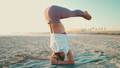 Beautiful strong yogi girl doing headstand while practicing yoga poses by the sea - PhotoDune Item for Sale