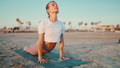 Young woman looking sporty doing yoga exercise and stretching on the beach - PhotoDune Item for Sale
