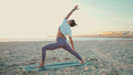 Pretty woman in sportswear doing stretching workout during yoga class on beach - PhotoDune Item for Sale