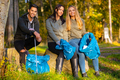 Focused team of young volunteers collecting garbage to protect the environment - PhotoDune Item for Sale