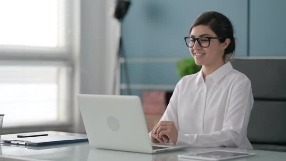 Indian Businesswoman Talking on Video Call on Laptop in Office